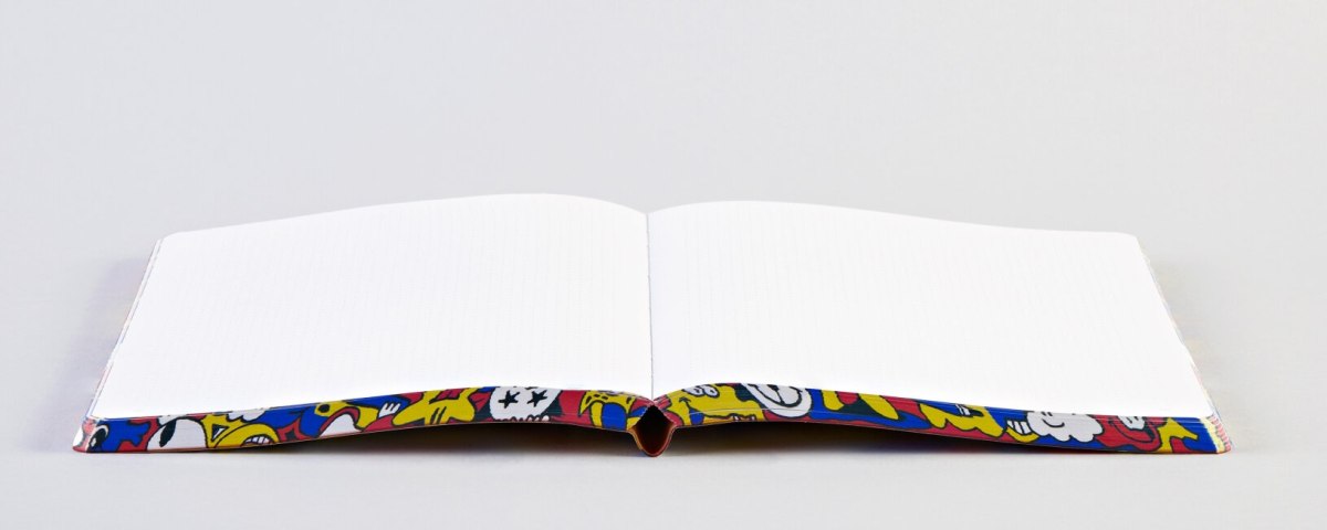Otwarty notatnik Pride Parade z kolorową okładką i pustymi kartkami do pisania