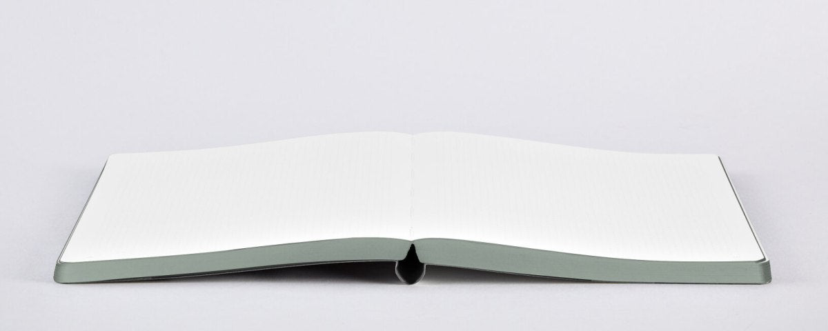 Otwarty notatnik Graphic L Words by Heyday z pustymi białymi stronami na białym tle