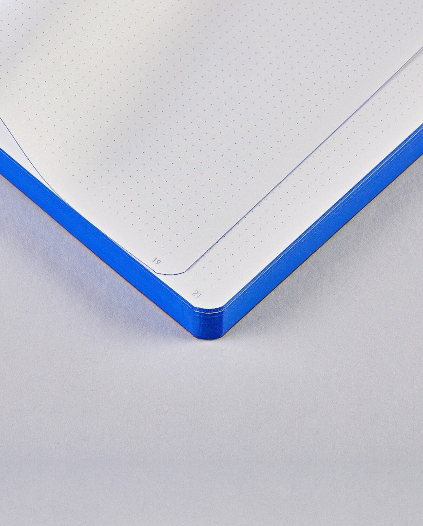 Otwarty notatnik Free Hugs z niebieską okładką i papierem w kropki do pisania i szkicowania