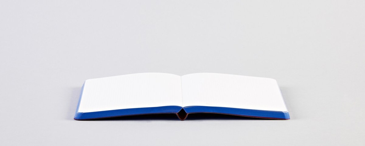 Notatnik Free Hugs z otwartymi pustymi białymi stronami na szarym tle