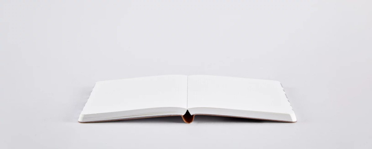 Otwarty pusty notatnik Write Wrong z jasnymi kartkami na białym tle