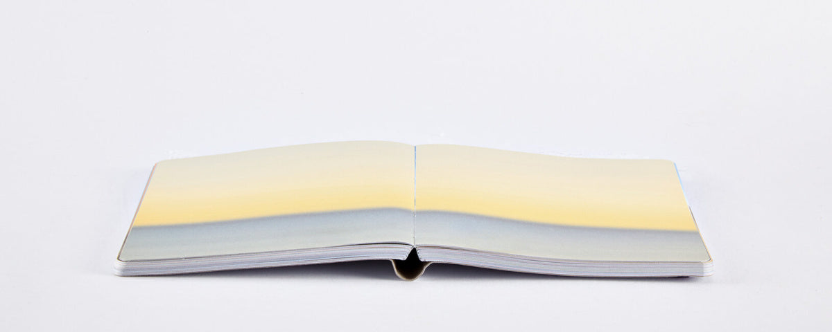 Otwarty notatnik inspirowany Mood z kolorowymi stronami od Yamann na białym tle