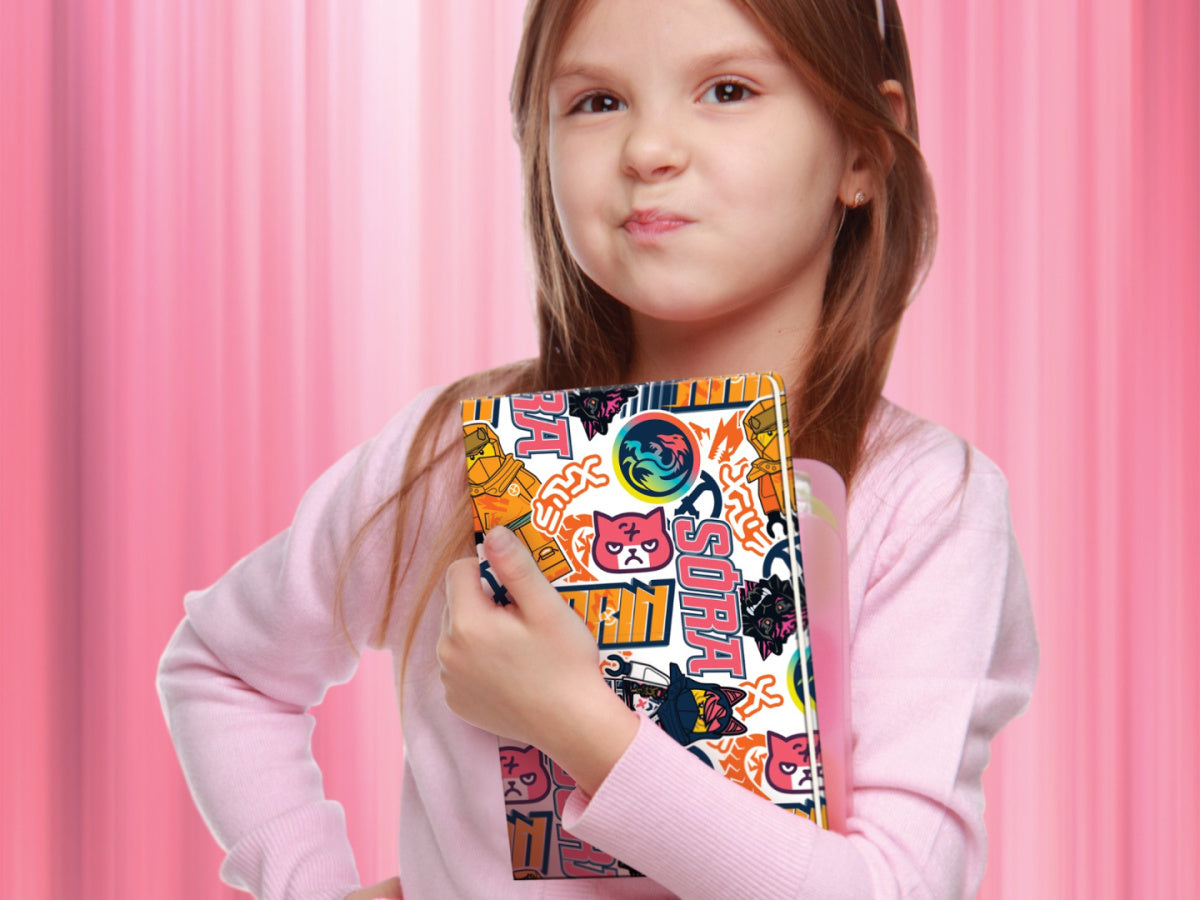 Dziewczynka trzyma w ramionach kolorowy notatnik LEGO Ninjago na różowym tle