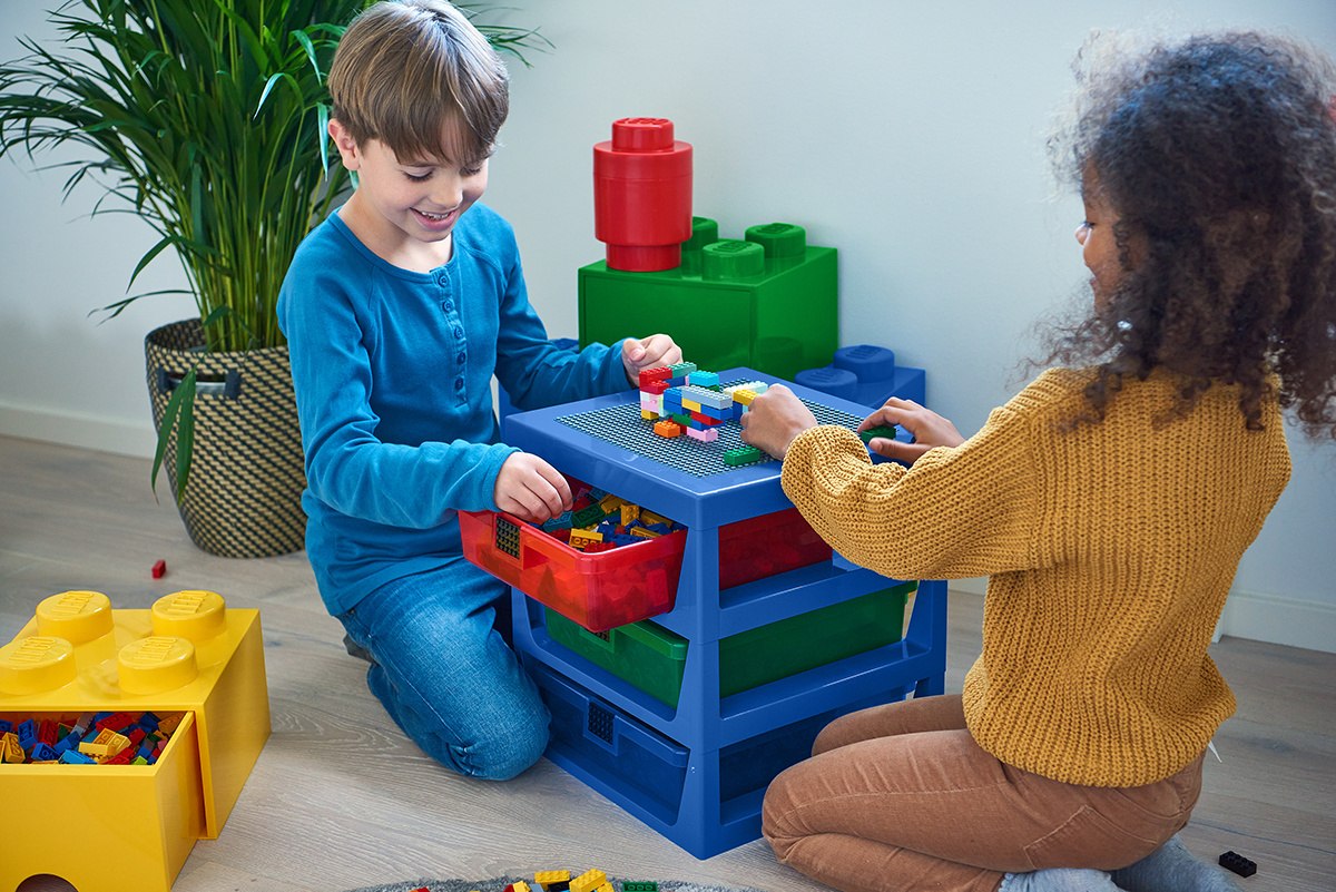 Dzieci bawiące się pojemnikiem klocek LEGO czerwony do przechowywania klocków w pokoju zabaw