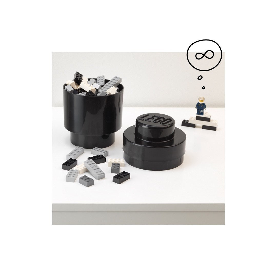Czarny okrągły pojemnik LEGO czarny na klocki z pokrywką i klockami na białym stole