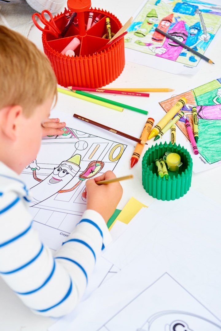 Dziecko kolorujące obrazek przy biurku z organizerem na biurko Crayola fioletowy do przechowywania kredek i przyborów