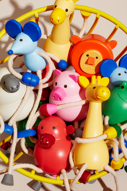 Kolorowa drewniana figurka żyrafa wśród innych drewnianych zwierzątek na dziecięcej karuzeli
