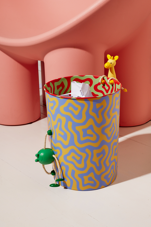 Kolorowy pojemnik z abstrakcyjnym wzorem z zieloną drewnianą figurką żaba od Areaware