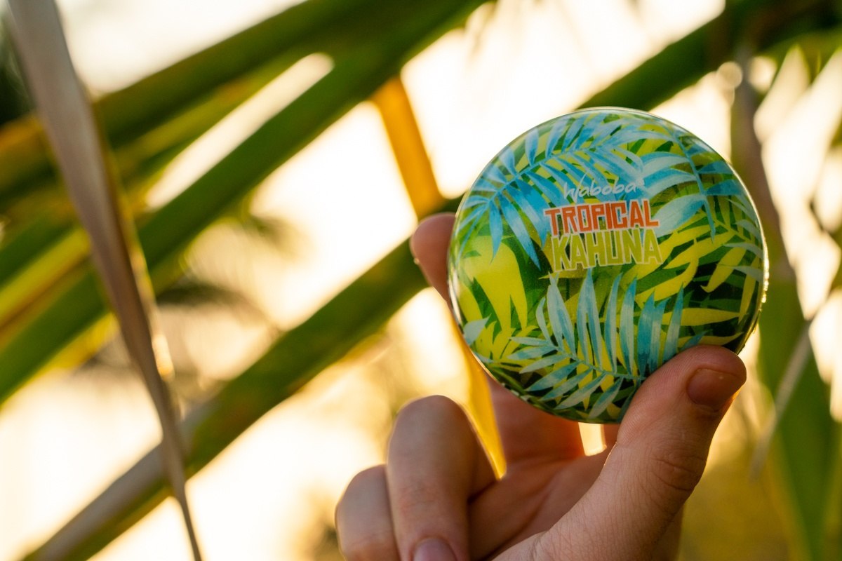 Piłka na wodę Waboba Tropical Kahuna z tropikalnym wzorem trzymana na tle zielonych liści