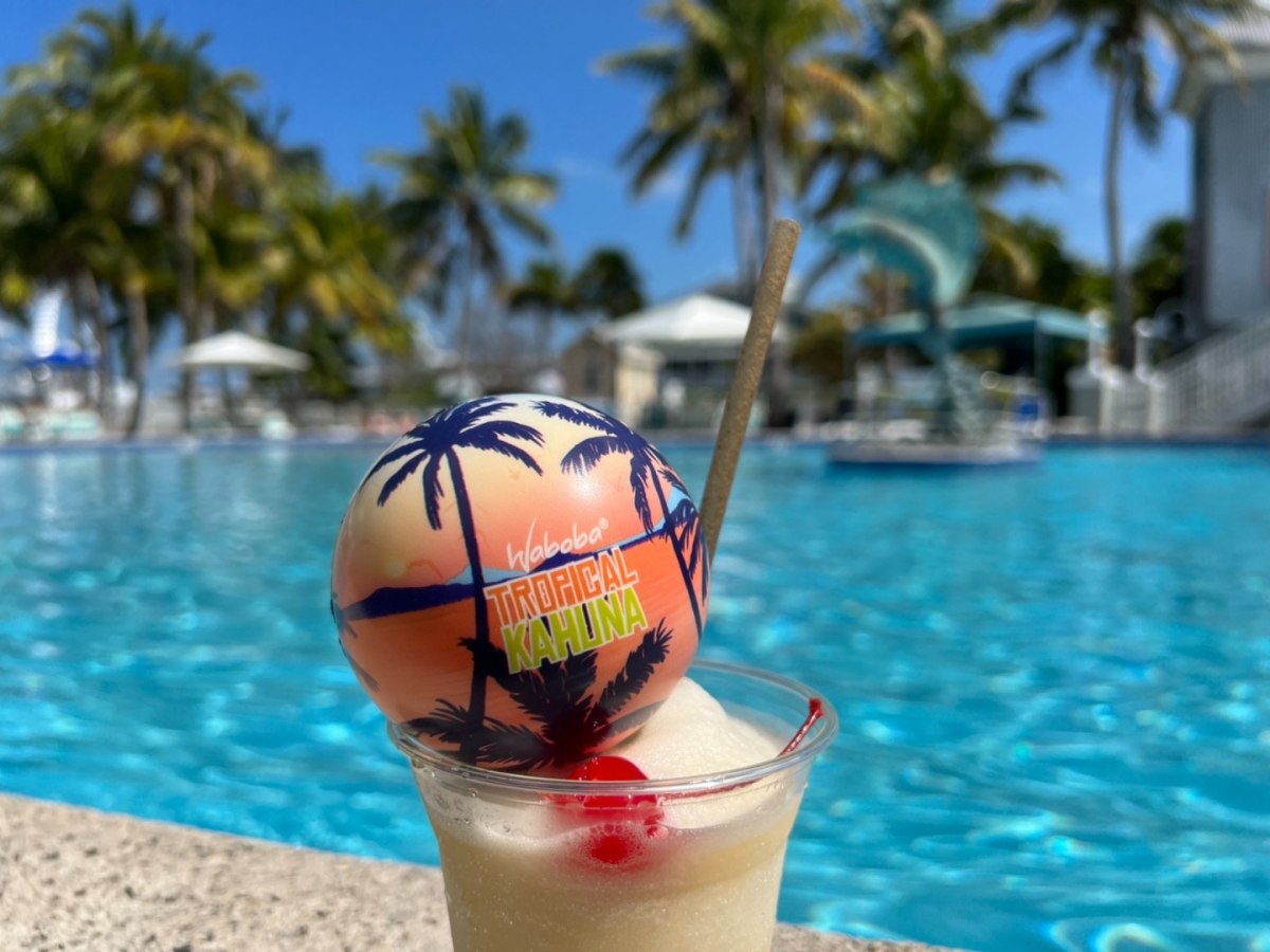Kolorowa piłka na wodę Waboba Tropical Kahuna z palmami obok basenu i koktajlu