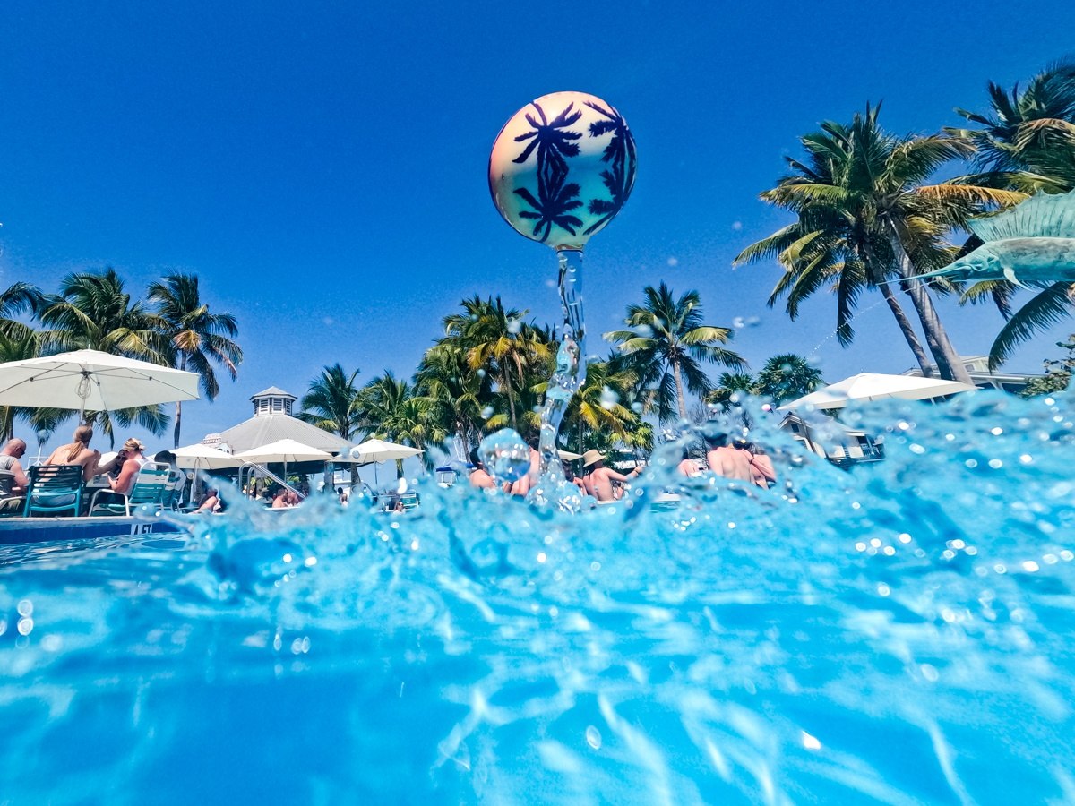 Piłka na wodę Waboba Tropical Kahuna unosząca się nad basenem wśród palm i parasoli