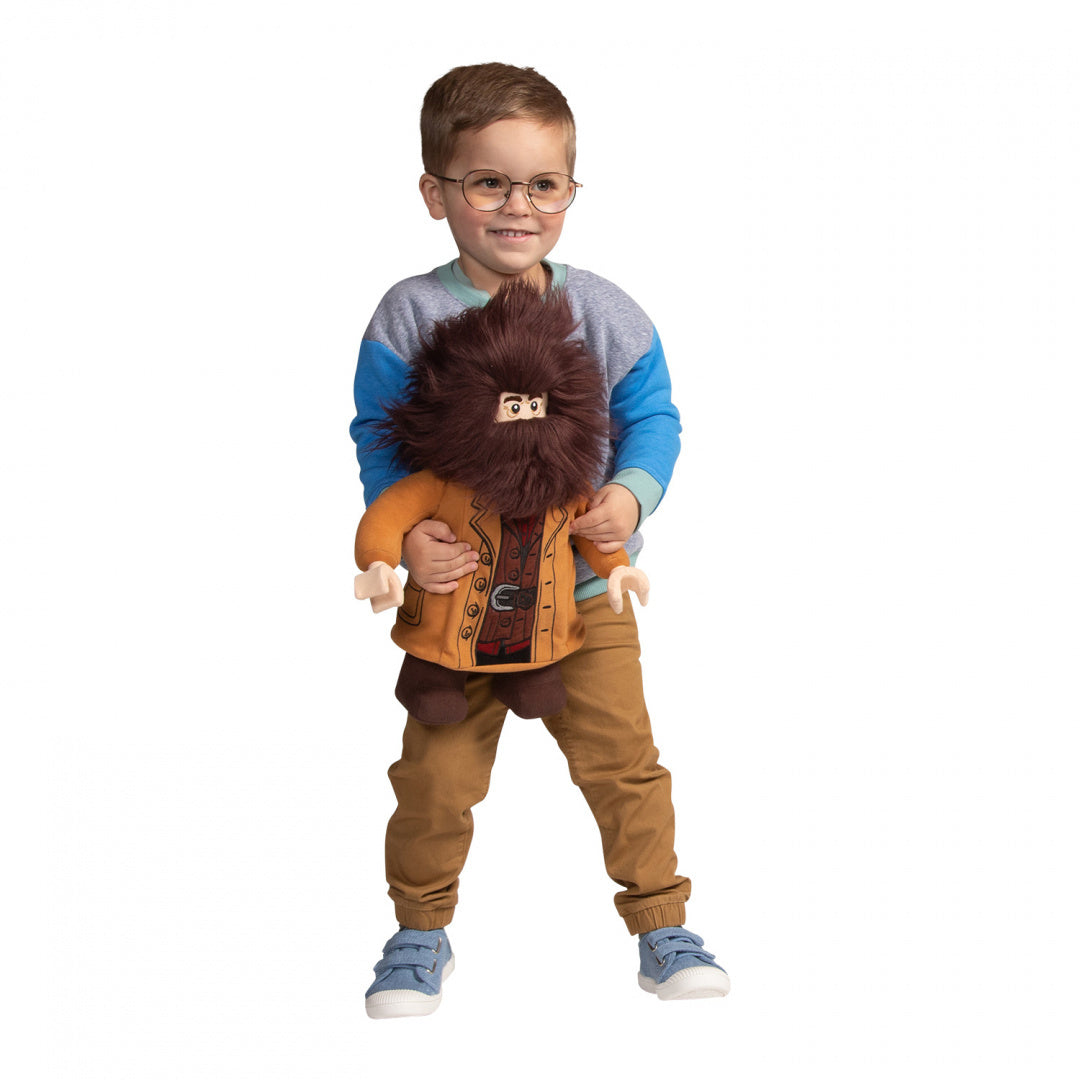 Chłopiec trzyma pluszaka Hagrid Lego Harry Potter w pomarańczowej kurtce i okularach