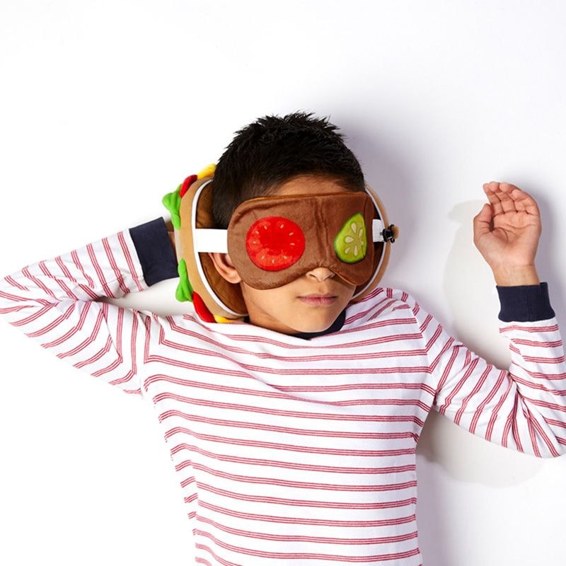 Pluszowa poduszka podróżna burger i opaska na oczy na twarzy śpiącego dziecka