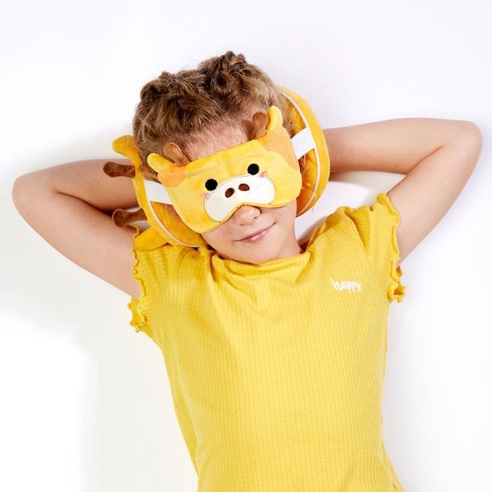 Dziecko z maską do spania w kształcie pluszowego zwierzaka na pluszowej poduszce podróżnej dla dzieci