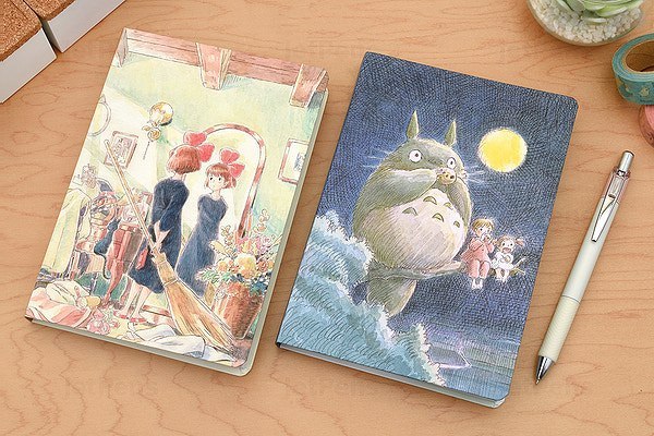 Notatnik Kiki Studio Ghibli z ilustracjami z filmu w miękkiej okładce na drewnianym biurku