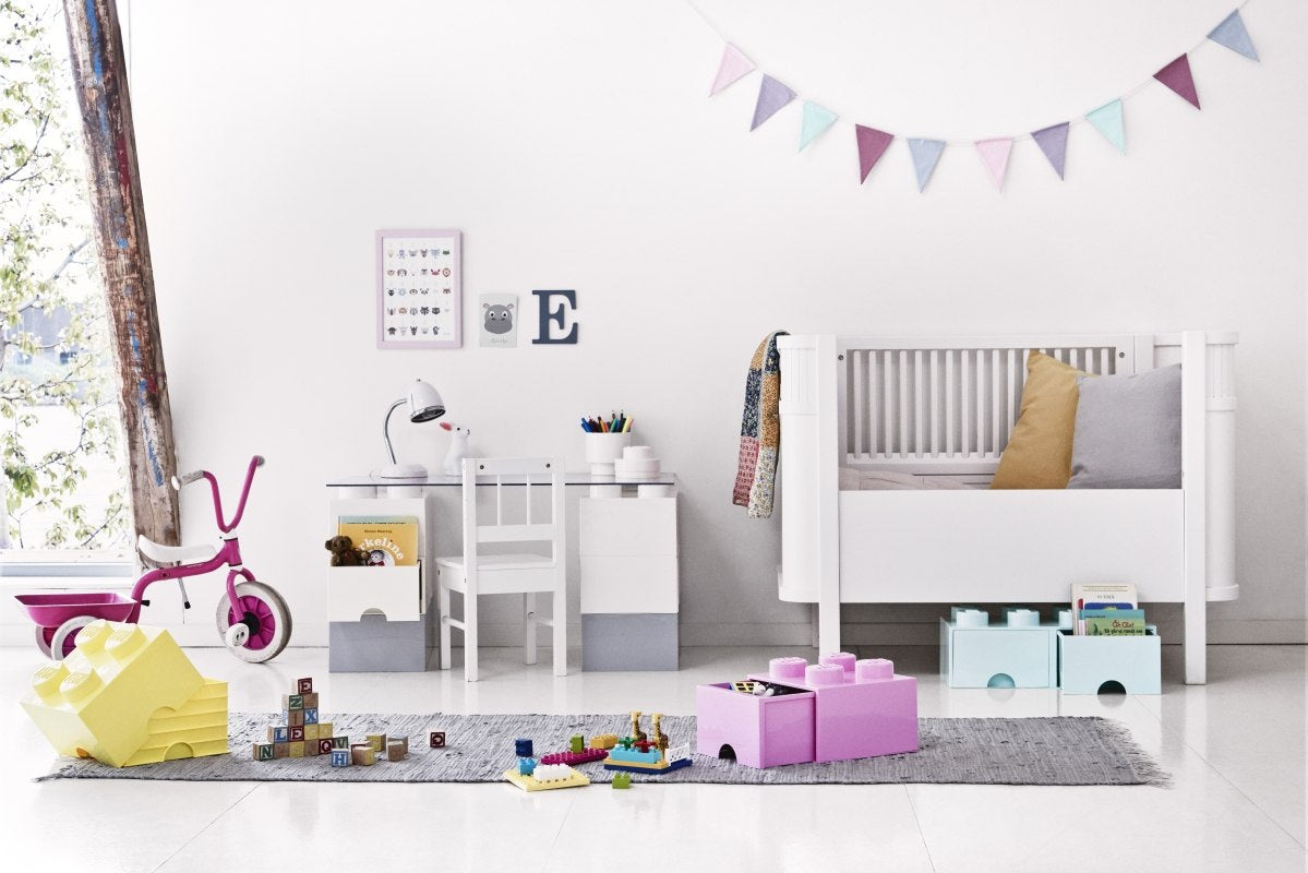 Pokój dziecięcy z białym łóżkiem i biurkiem oraz szufladami LEGO Brick 8 morski i różowa na dywanie