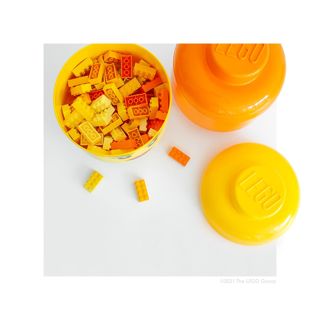 Pojemnik LEGO duża głowa chłopiec wypełniony żółtymi i pomarańczowymi klockami LEGO