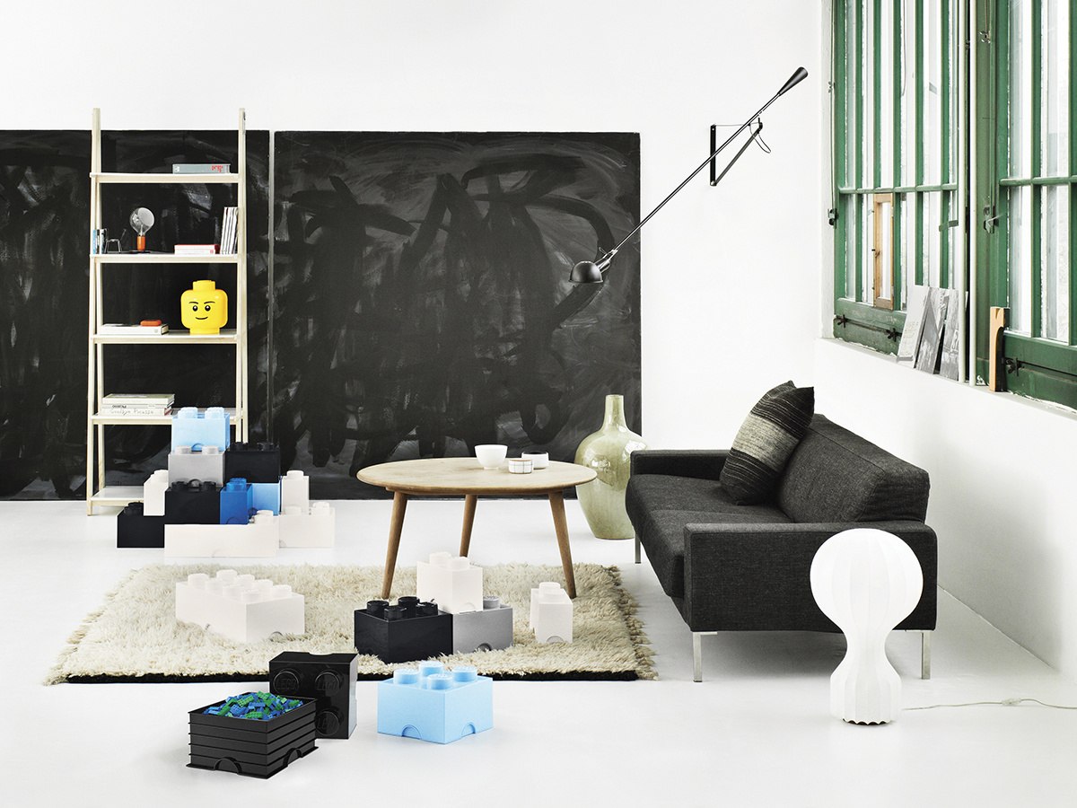 Pojemnik LEGO jasnoniebieski w nowoczesnym salonie z czarną sofą i białym dywanem