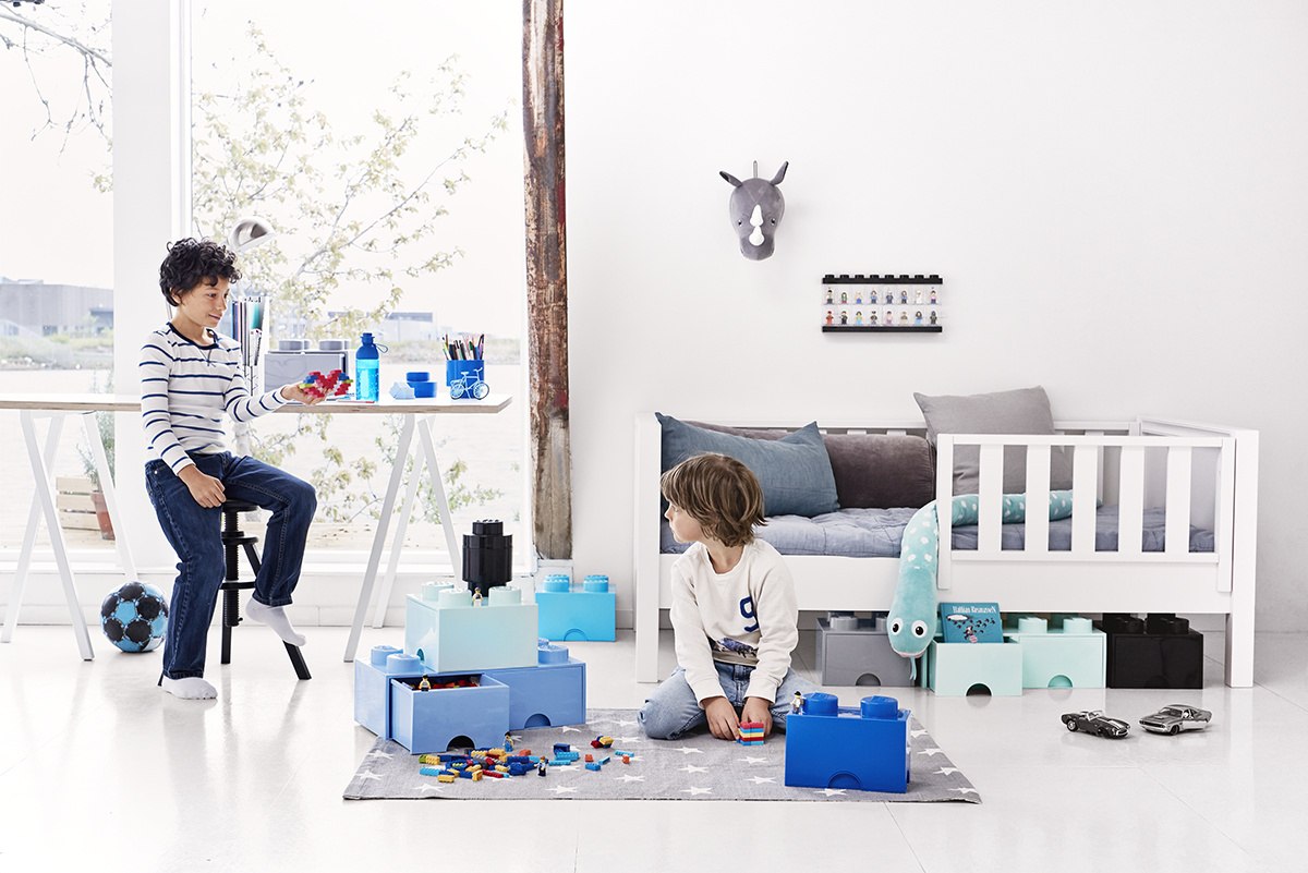 Pojemnik LEGO na zabawki w pokoju dziecięcym z chłopcami bawiącymi się klockami