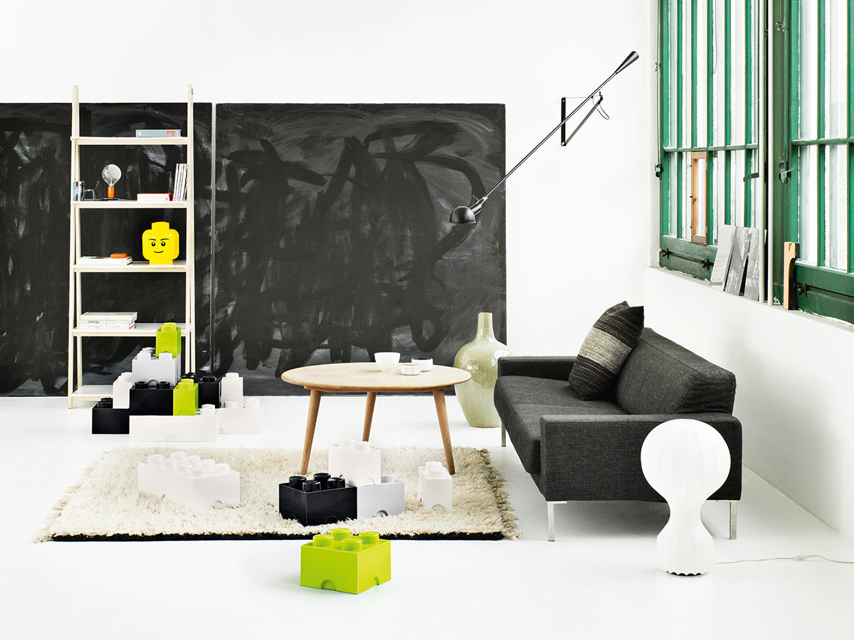 Nowoczesny salon z szarą sofą i pojemnikiem LEGO Brick 4 szary na dywanie obok stolika