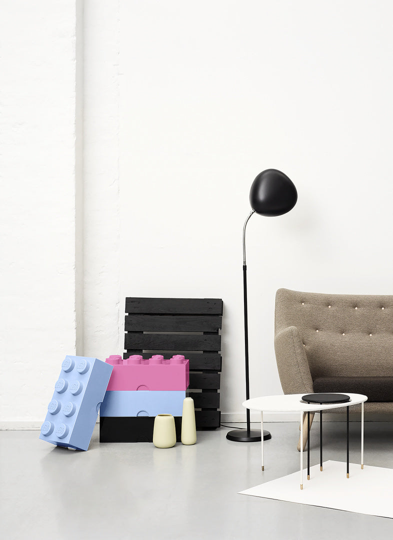 Pojemnik LEGO na zabawki w kolorach różowym, niebieskim i czarnym w nowoczesnym salonie