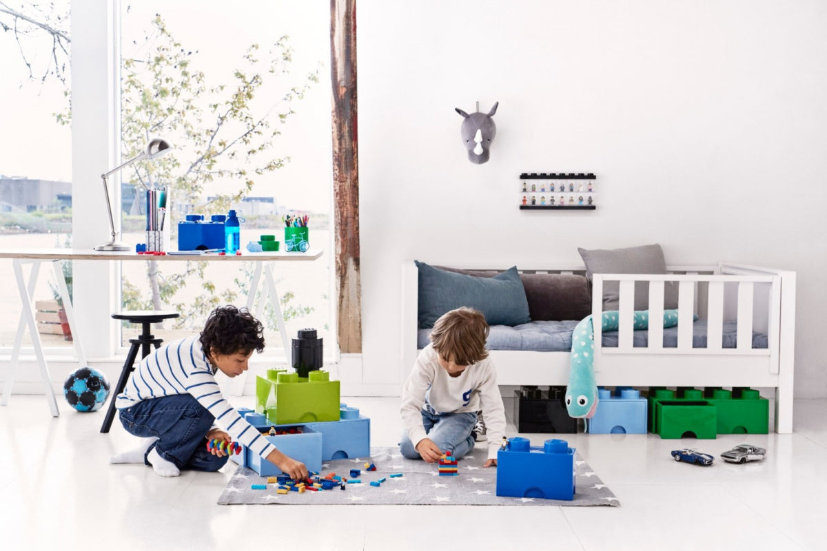 Dzieci bawiące się klockami LEGO obok pojemników do przechowywania zabawek w jasnym pokoju dziecięcym pojemnik LEGO na zabawki