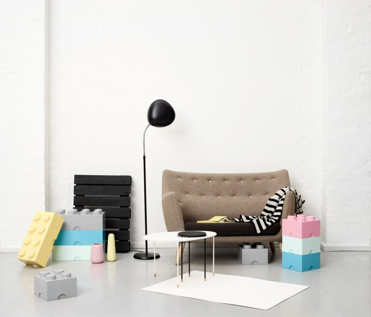 Pojemnik LEGO Brick 4 jasnoróżowy w nowoczesnym salonie z kanapą i lampą stojącą