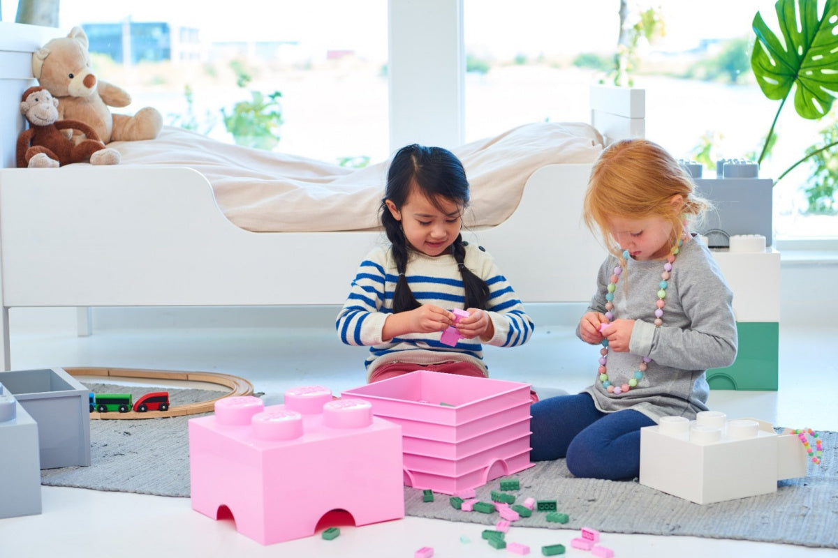 Pojemnik LEGO Brick 4 biały na zabawki w pokoju dziecięcym z dziećmi bawiącymi się elementami LEGO