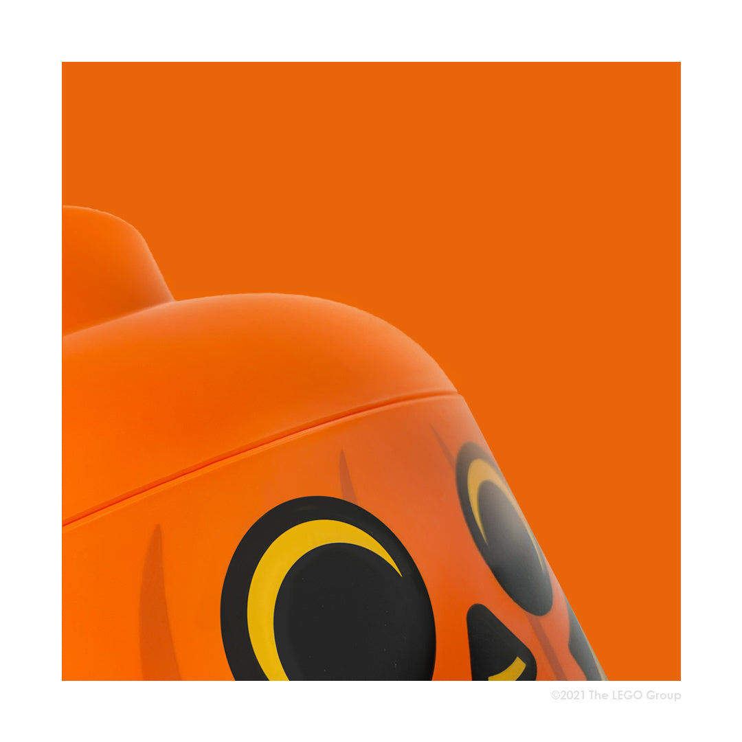 Pojemnik LEGO dynia w jaskrawym pomarańczowym kolorze z dużymi oczami i zakrętką