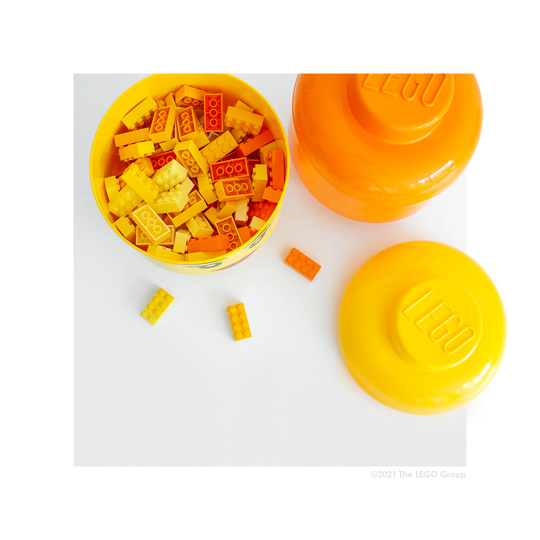 Pojemnik LEGO głowa chłopiec wypełniony żółtymi i pomarańczowymi klockami LEGO