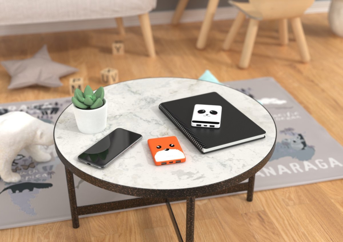 Powerbank lis 5000 mAh w pomarańczowym etui obok smartfona i notesu na białym stole