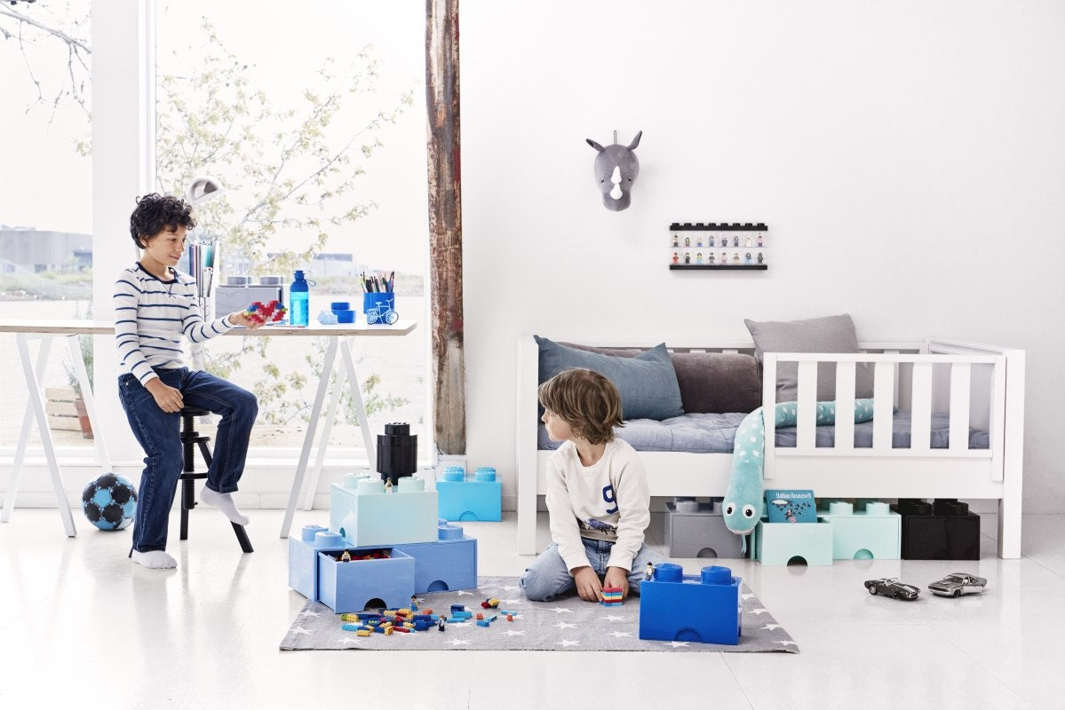 Butelka LEGO 500 ml fioletowa na stole w jasnym pokoju dziecięcym z dwójką bawiących się dzieci