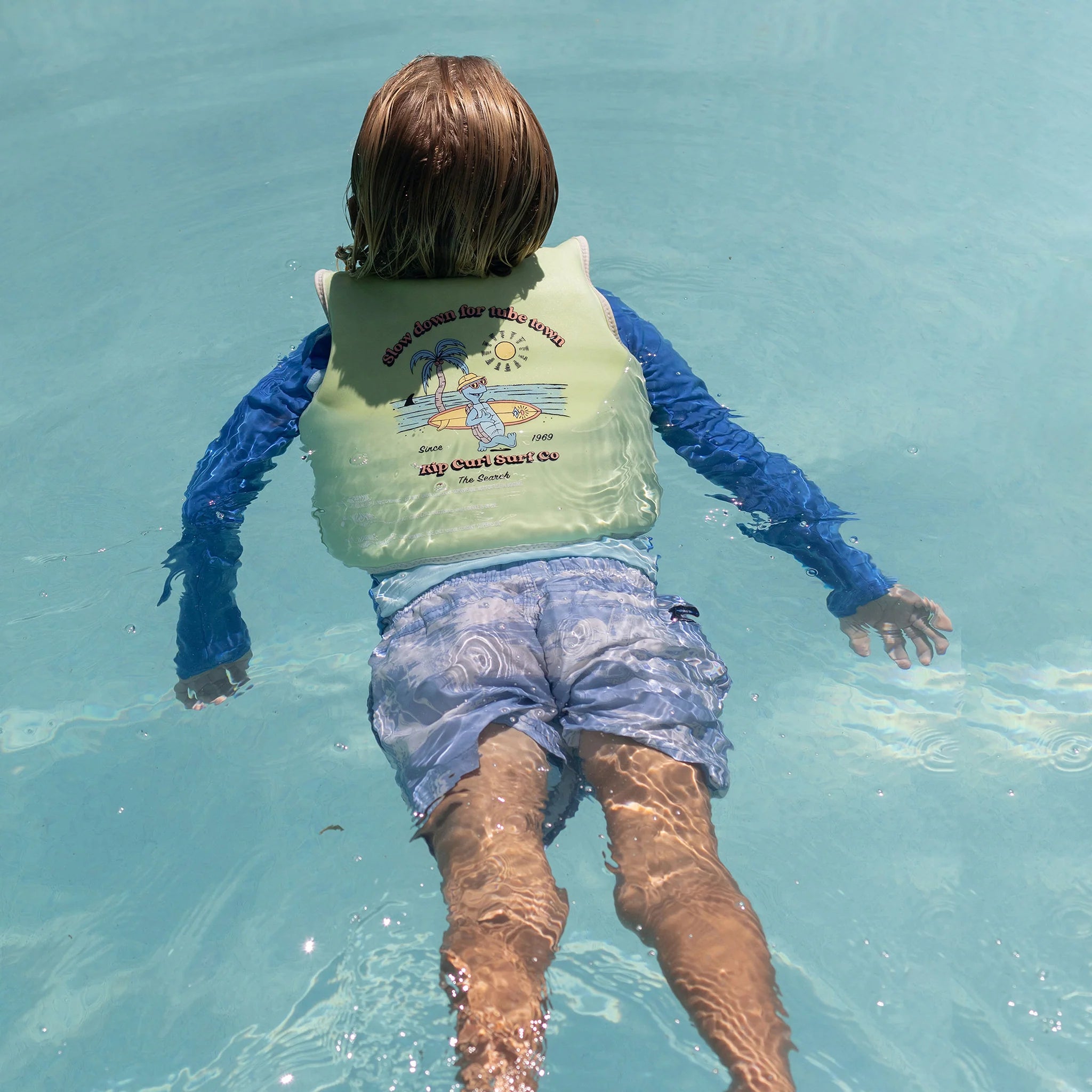 Dziecko pływające w basenie z kamizelką do pływania dla dzieci marki Yamann