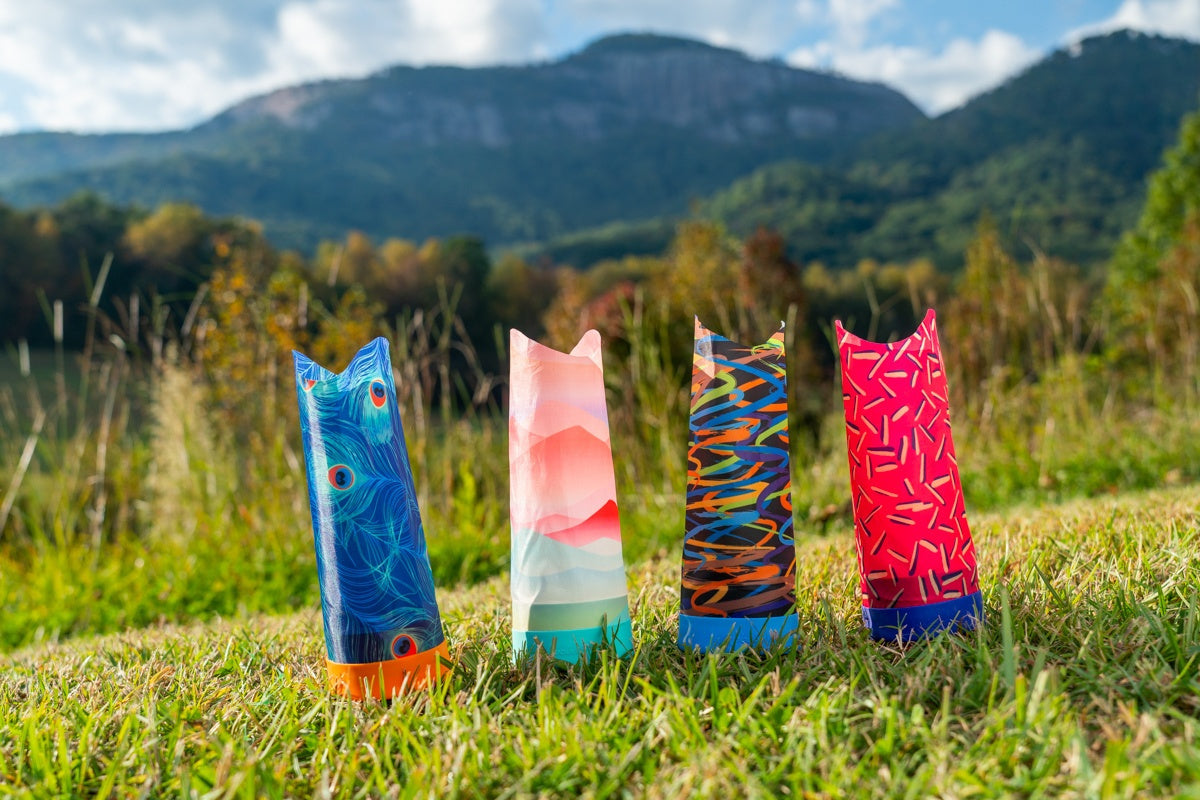 Kolorowe rzutki Waboba Airlyft dla dzieci stojące na trawie z górskim tłem