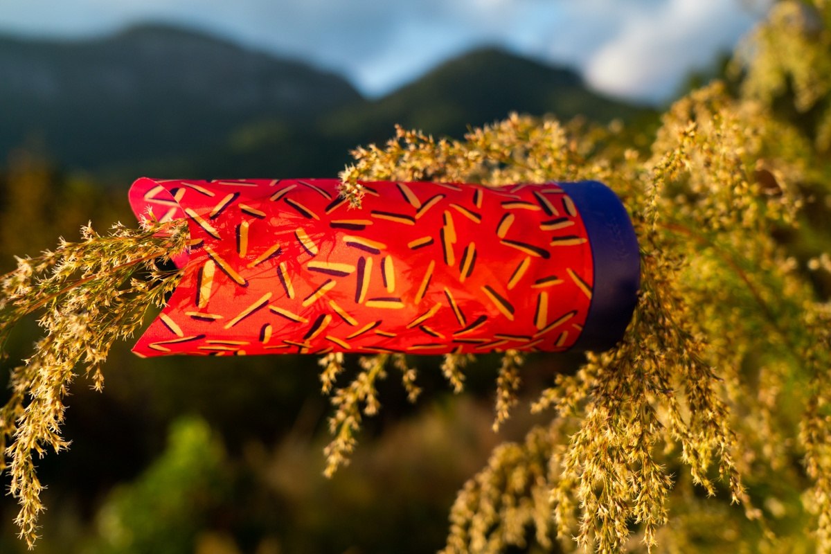 Czerwona rzutka Waboba Airlyft z wzorem na tle zielonych krzewów i górskiego krajobrazu