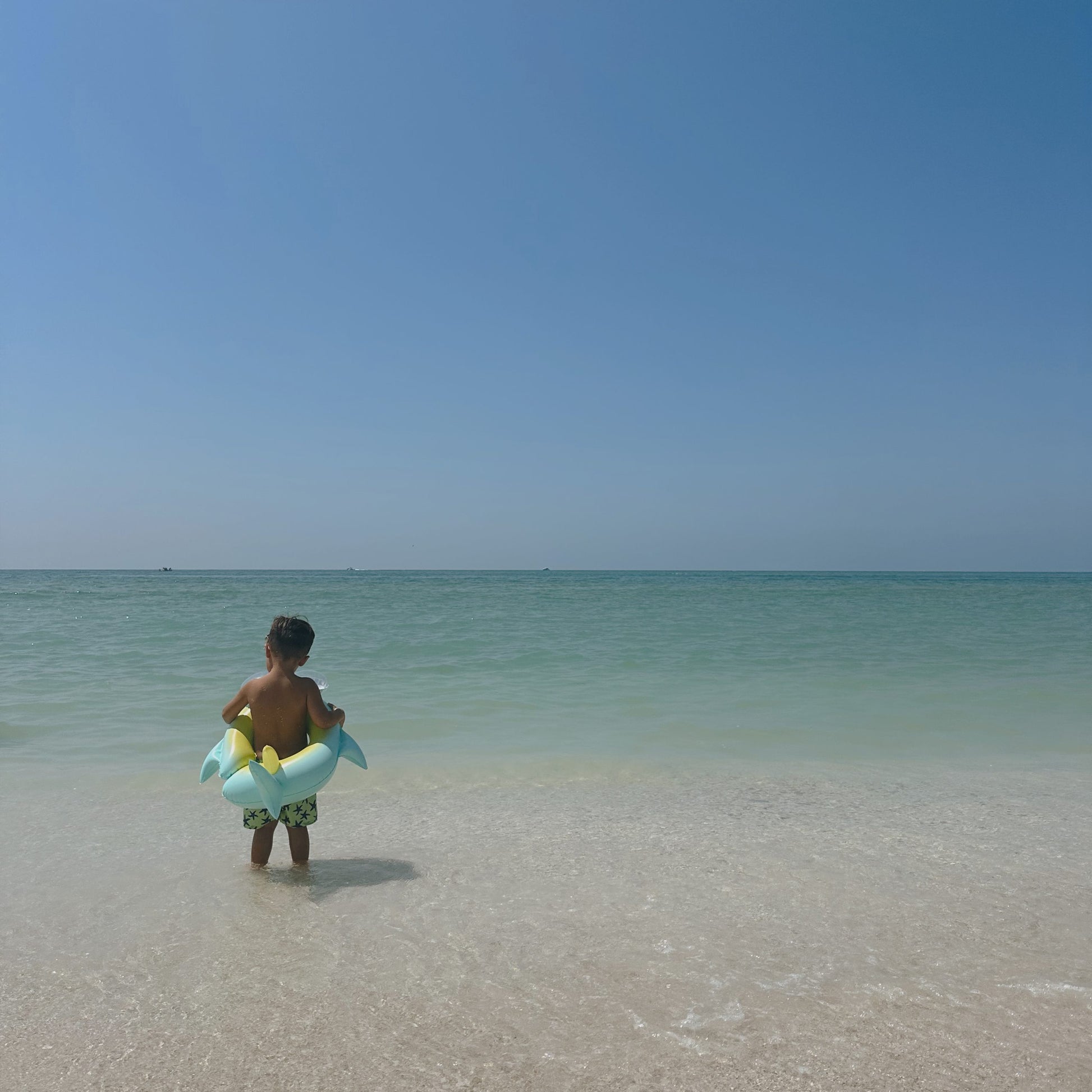 Dziecko na plaży z kołem do pływania dla dzieci przygotowane do wejścia do morza