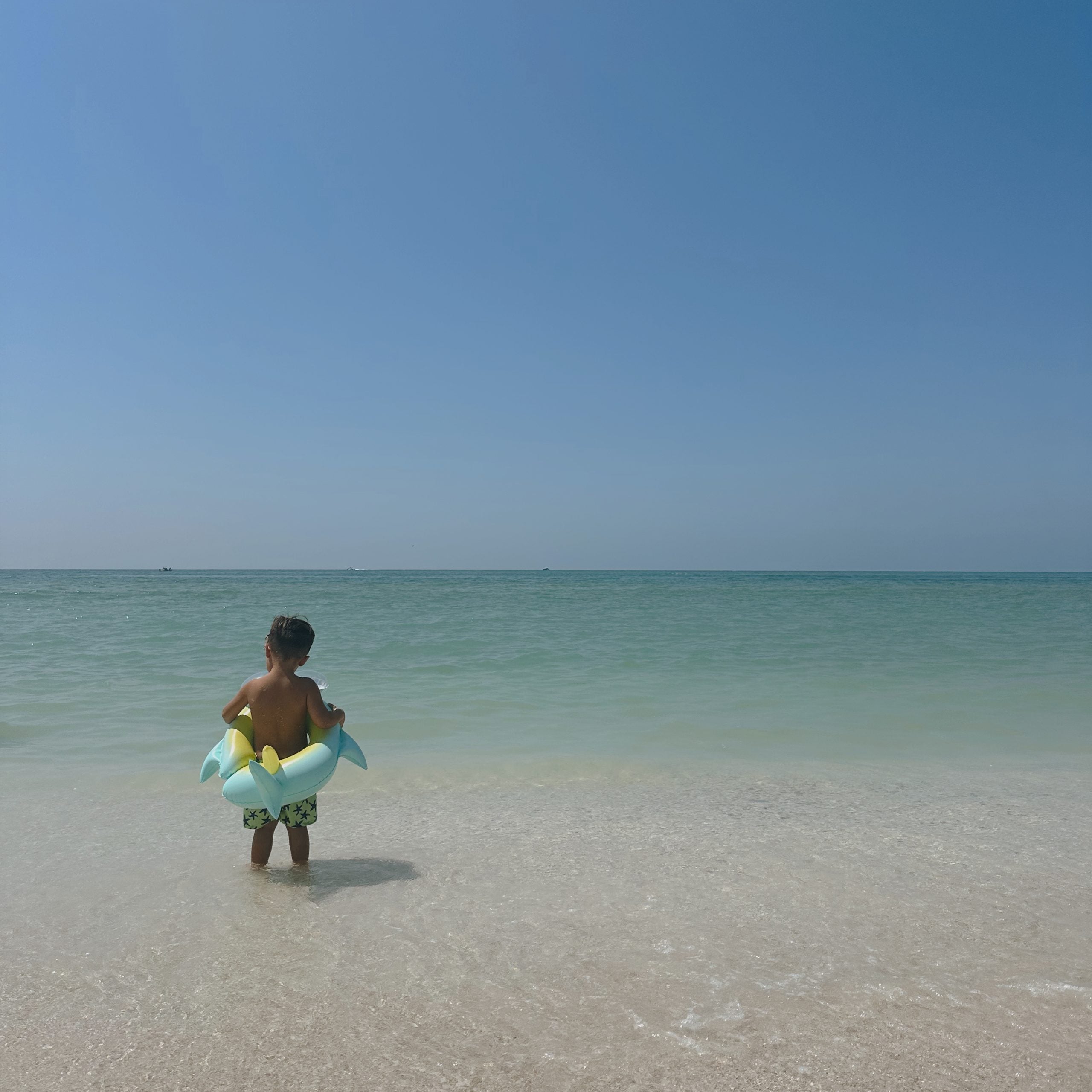 Dziecko na plaży z kołem do pływania dla dzieci przygotowane do wejścia do morza