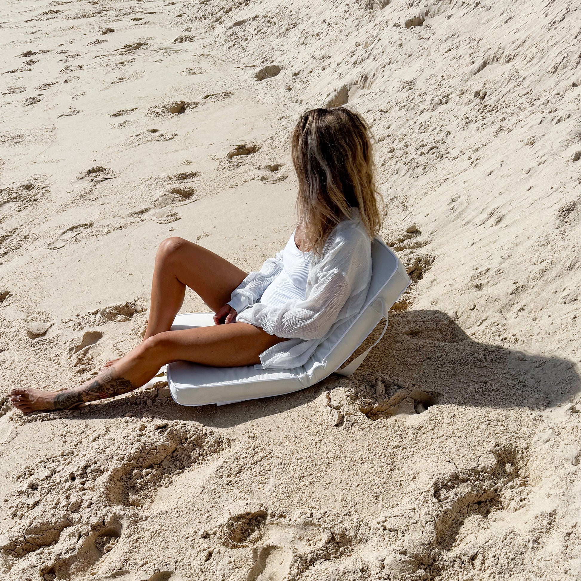 Składane krzesło Casa Cream marki Sunny Life na plaży z wygodną poduszką do siedzenia