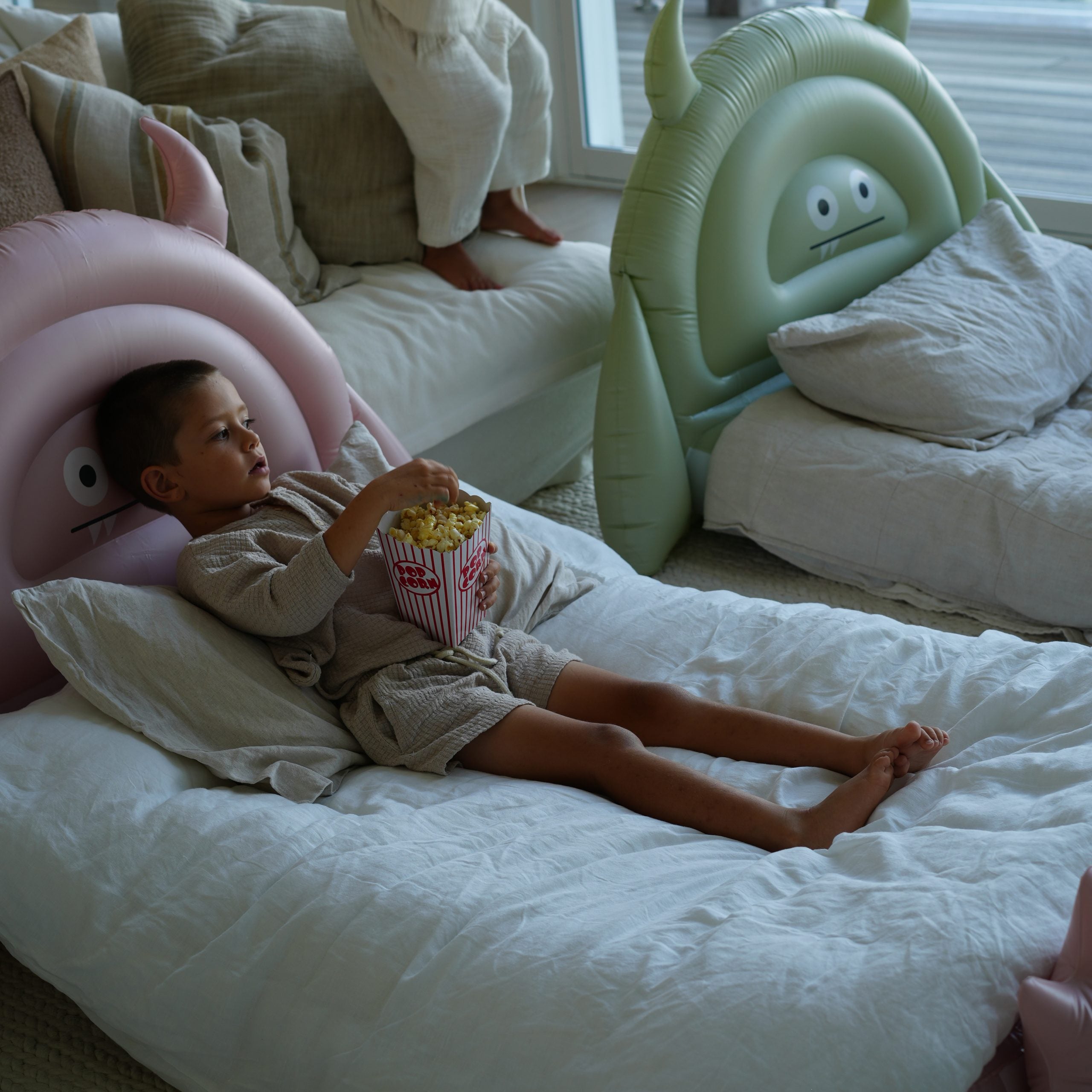 Dmuchane łóżko dla dzieci z kolorowym zabawnym oparciem, dziecko odpoczywa i je popcorn