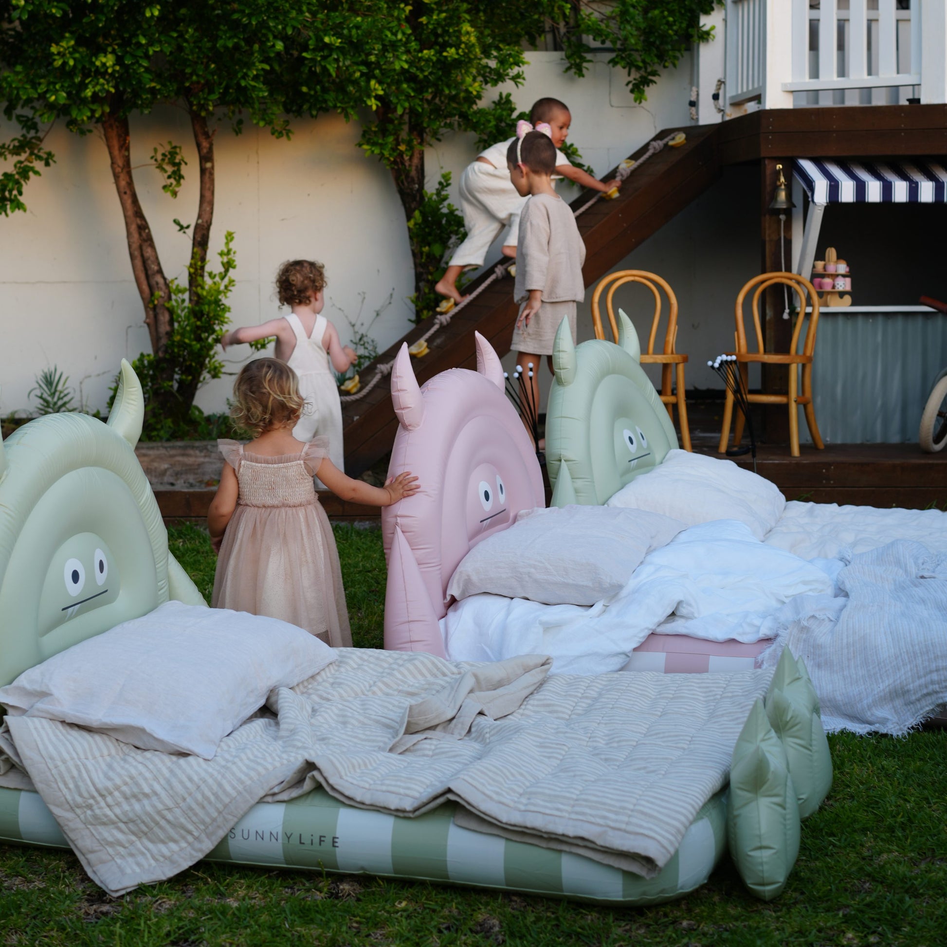 Kolorowe dmuchane łóżko dla dzieci z miękkimi poduszkami ustawione na trawie na zewnątrz
