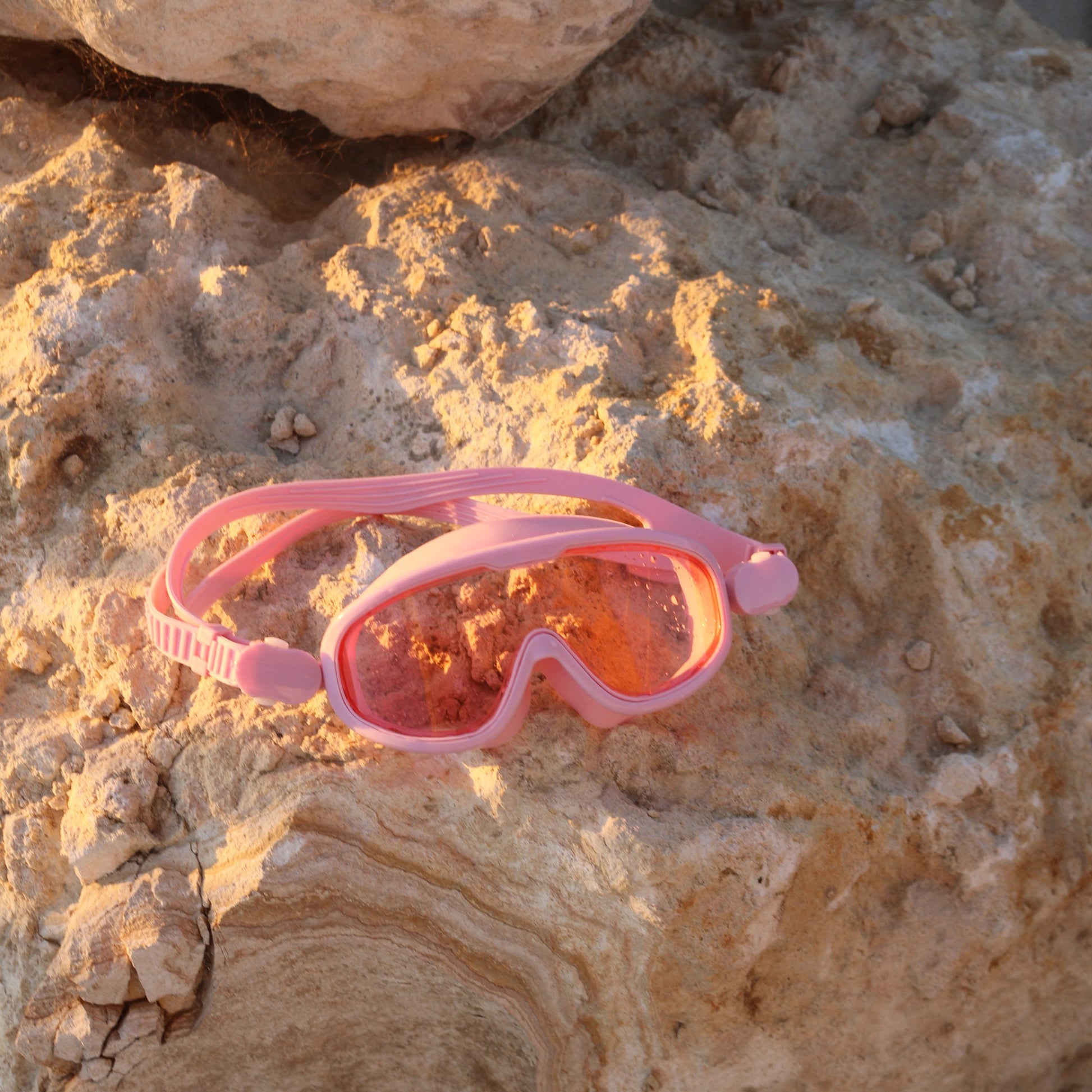 Różowa maska do pływania dla dzieci marki LOQI na skałach przy plaży