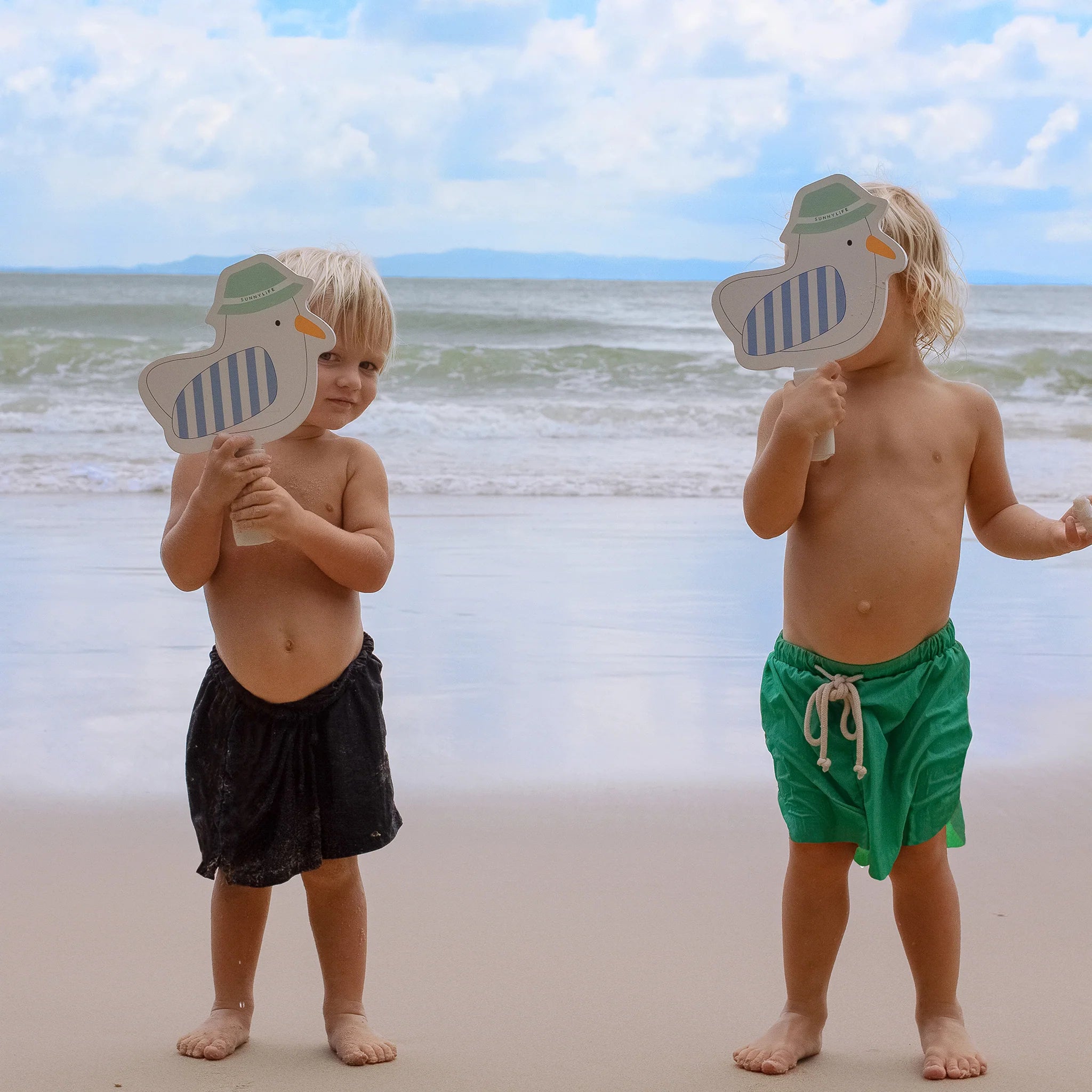 Dzieci na plaży z dziecięcymi rakietkami plażowymi w kształcie ptaków firmy LOQI