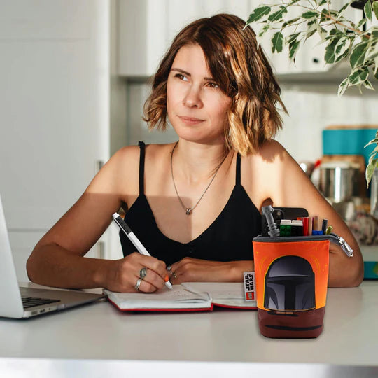 Kobieta pisząca przy biurku z piórnikiem LEGO Star Wars Mandalorian pełnym przyborów do pisania