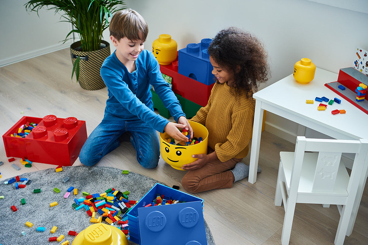 Dzieci bawiące się klockami LEGO obok czerwonej szuflady LEGO Brick 4 czerwona do przechowywania klocków