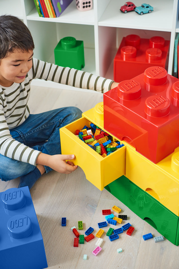 Chłopiec bawiący się szufladą LEGO Brick 8 żółta w kształcie klocka z kolorowymi klockami
