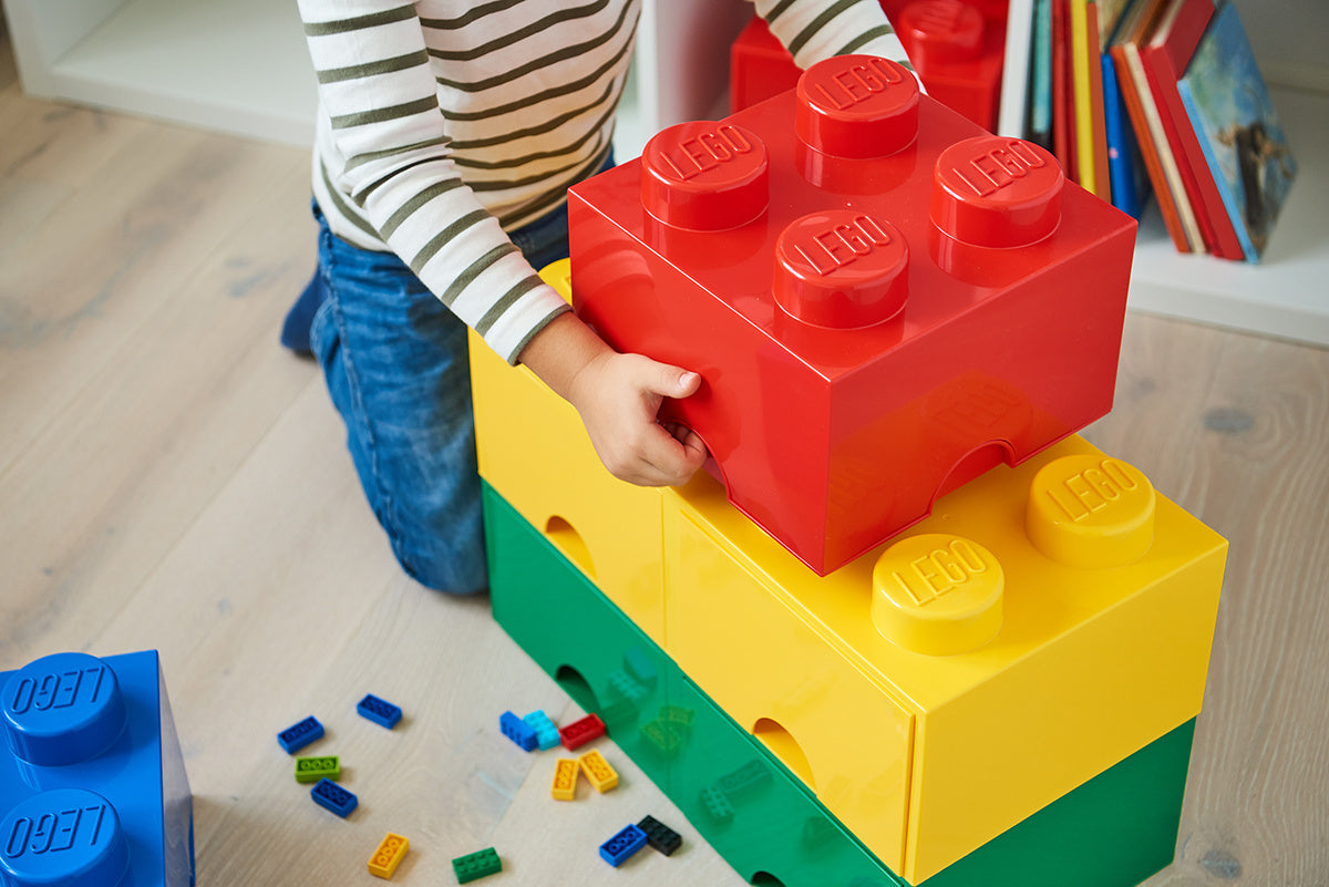 Dziecko bawiące się szufladą LEGO Brick 8 zieloną i innymi kolorowymi pojemnikami LEGO
