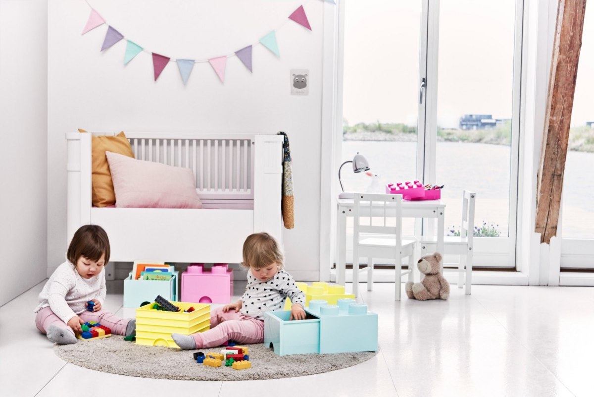 Dzieci bawiące się klockami z niebieską i żółtą szufladą LEGO do przechowywania w jasnym pokoju dziecięcym