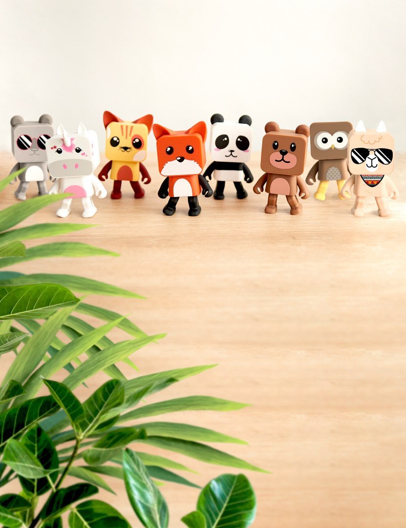 Tańczący głośnik bezprzewodowy panda i inne kolorowe zabawne postacie na drewnianym stole