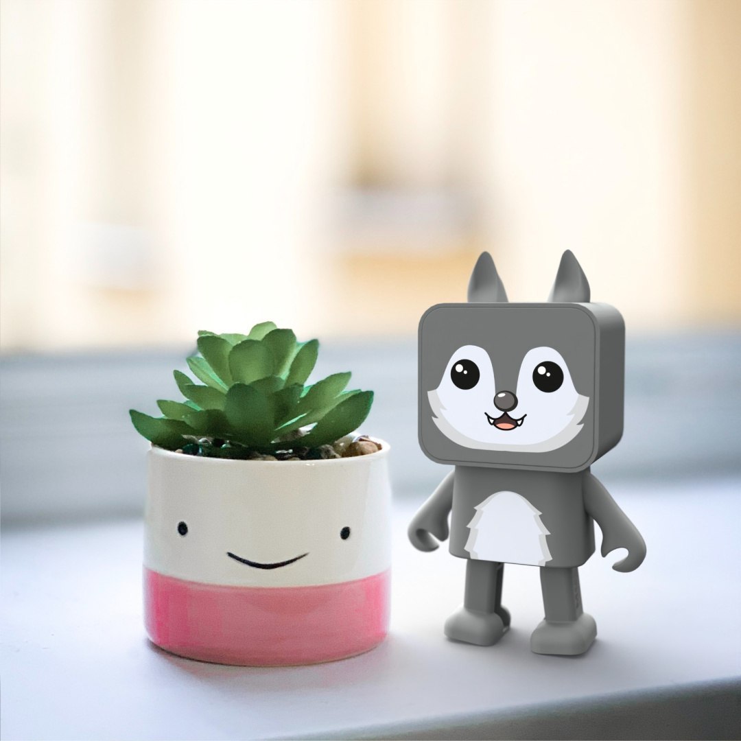 Tańczący głośnik bezprzewodowy wilk stojący obok małej doniczki z sukulentem