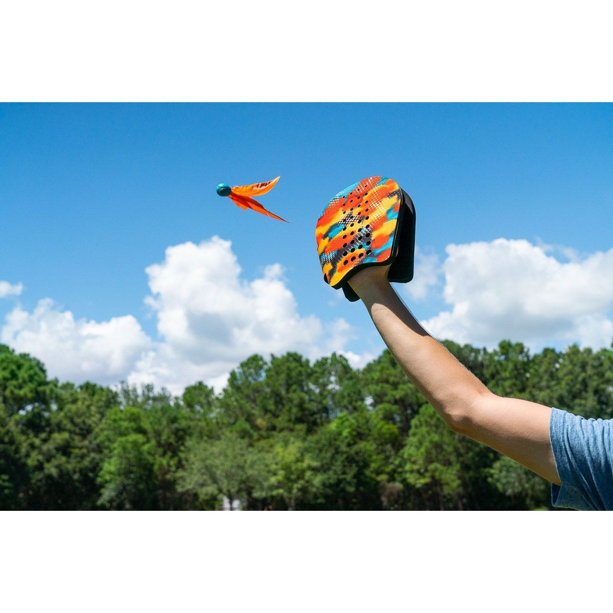 Waboba terenowa gra zręcznościowa dla dzieci pokazująca rzut kolorowym latającym dyskiem na tle nieba